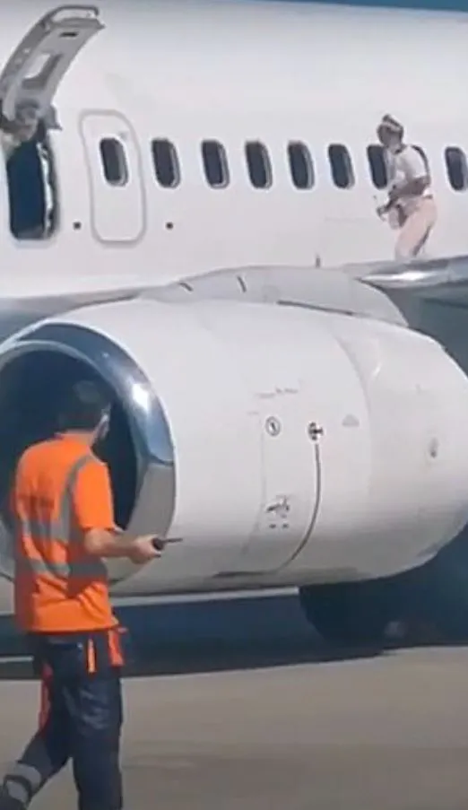mother walks on boeing 737 wing to cool down while waiting to disembark 13744