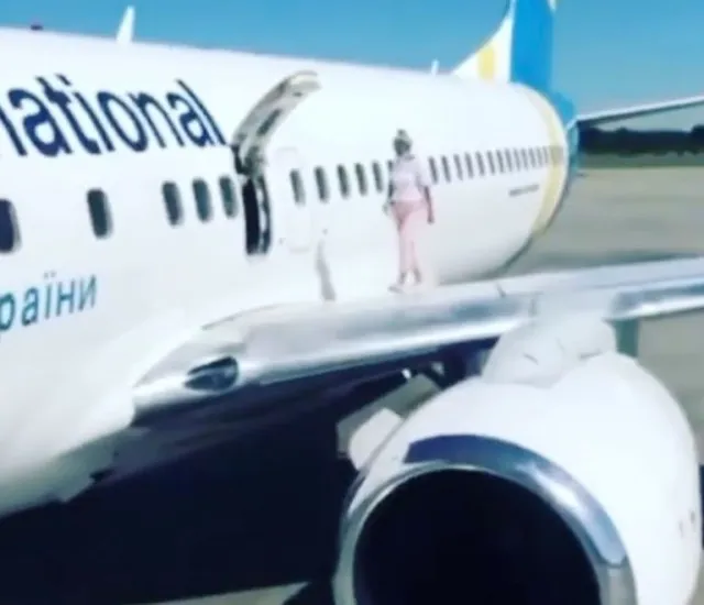 mother walks on boeing 737 wing to cool down while waiting to disembark 13742