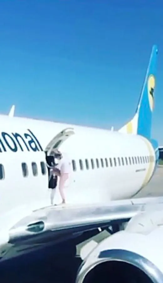 mother walks on boeing 737 wing to cool down while waiting to disembark 13743