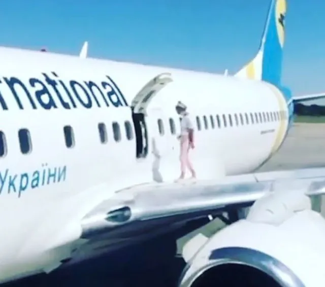 mother walks on boeing 737 wing to cool down while waiting to disembark 13741
