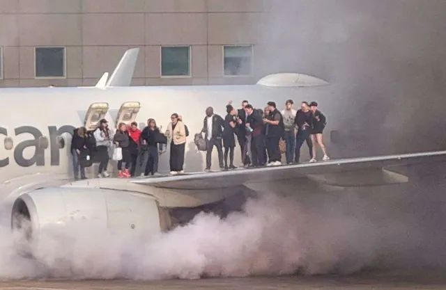 passengers stand on wing as they evacuate after plane bursts into flames at 19774