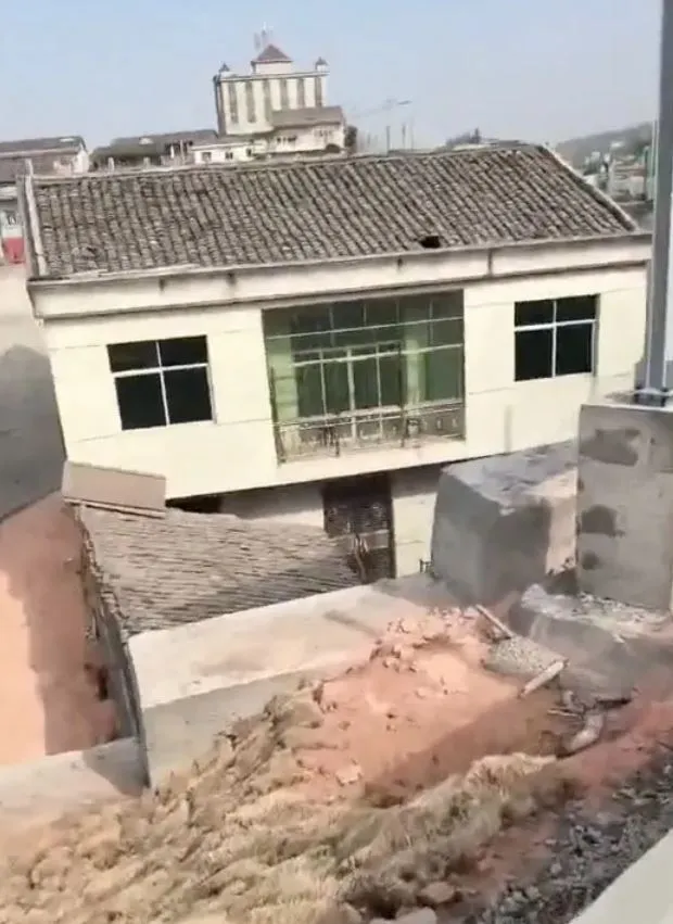a determined homeowner in china refuses to relocate, forcing construction c 19873