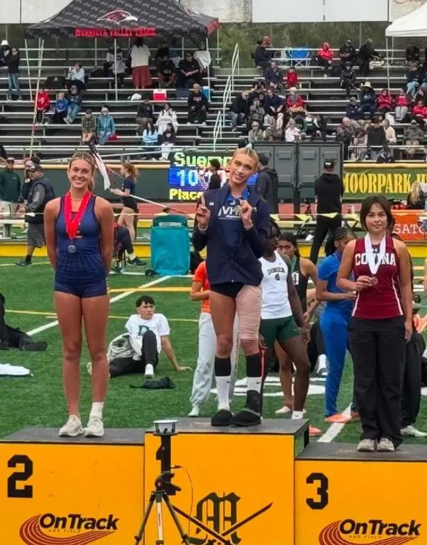 high school female track star poses on first-place podium after finishing s 24547